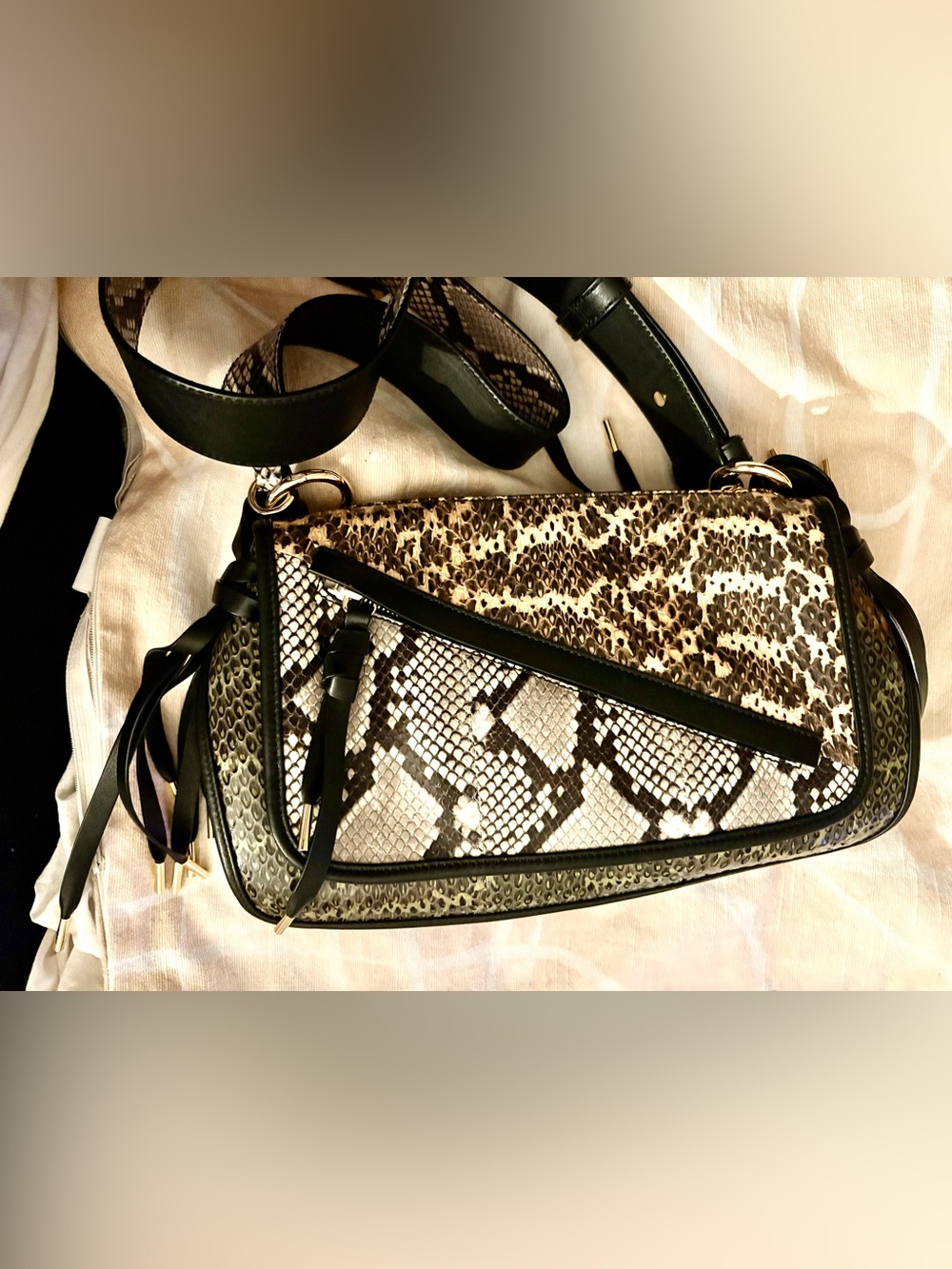 This BALLY python print shoulder bag features a distinctive tied leather tassel